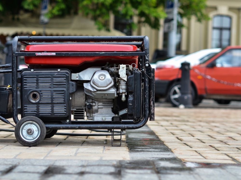 Portable generator with multiple outlets for mobile detailing, set on a paved surface.